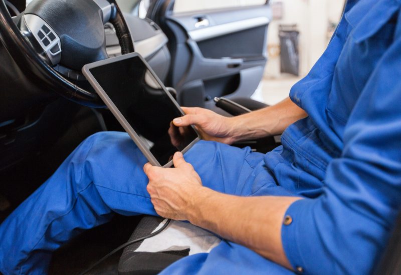 mechanic man with tablet pc making car diagnostic
